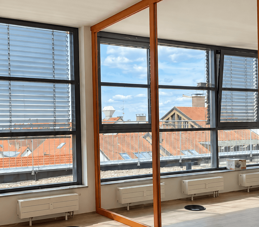 Heller, noch leerer Büroraum mit großen Fenstern und Blick über die Dächer