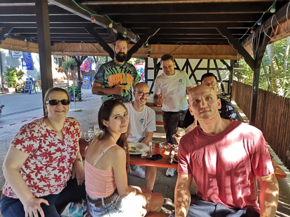 Das SimplyTest-Team sitzt beim Ausflug ins Schwarzachtal gut gelaunt unter einer Pergola an einem Tisch