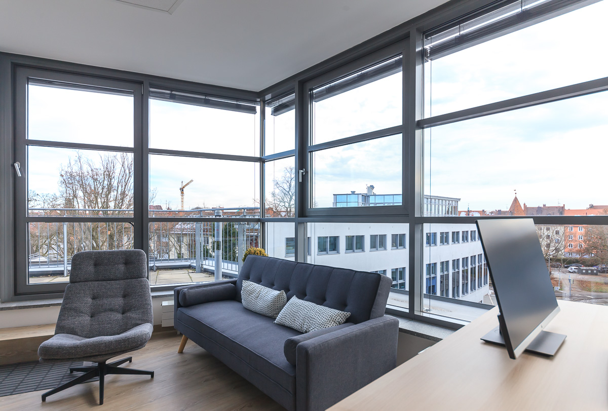 Lounge im neuen Büro mit Sofa, Sessel und großen Fenstern über Nürnberg