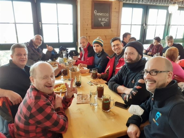 Das SimplyTest-Team sitzt nach der Wanderung in einer Berghütte an einem langen Tisch