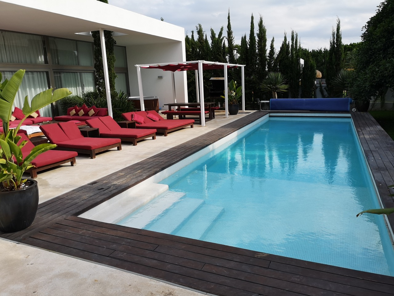 Pool und rote Sonnenliegen an der Unterkunft des Jahresworkshops 2019