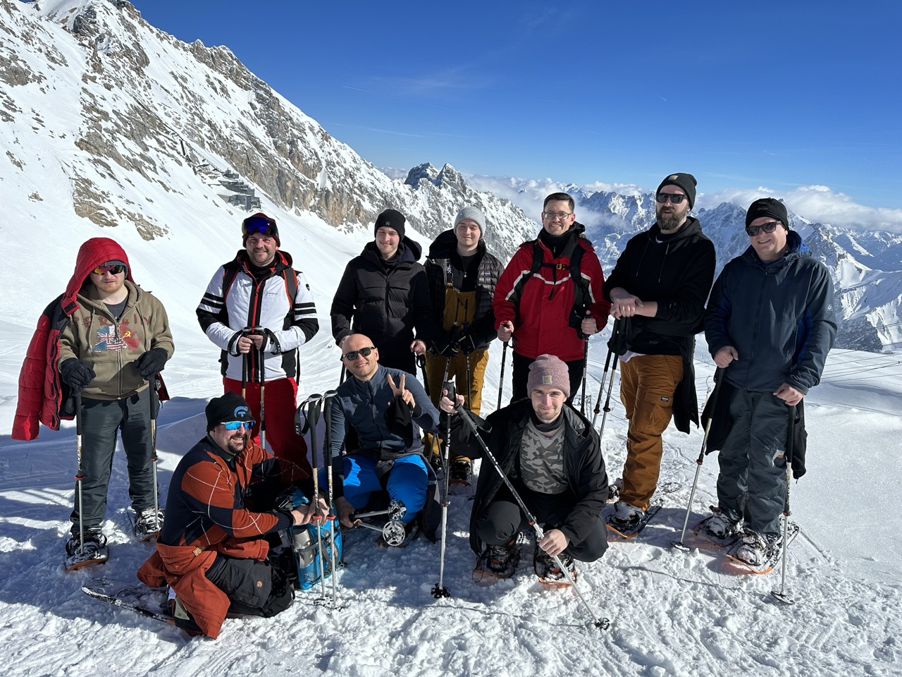Gruppenfoto des SimplyTest-Teams mit Schneeschuhen und Wanderstöcken im Schnee