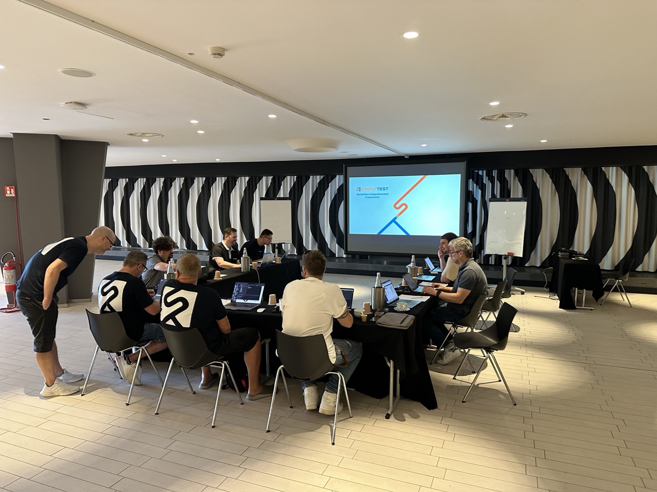 Das Team sitzt beim Jahresworkshop 2023 im Tagungsraum vor einer Leinwand
