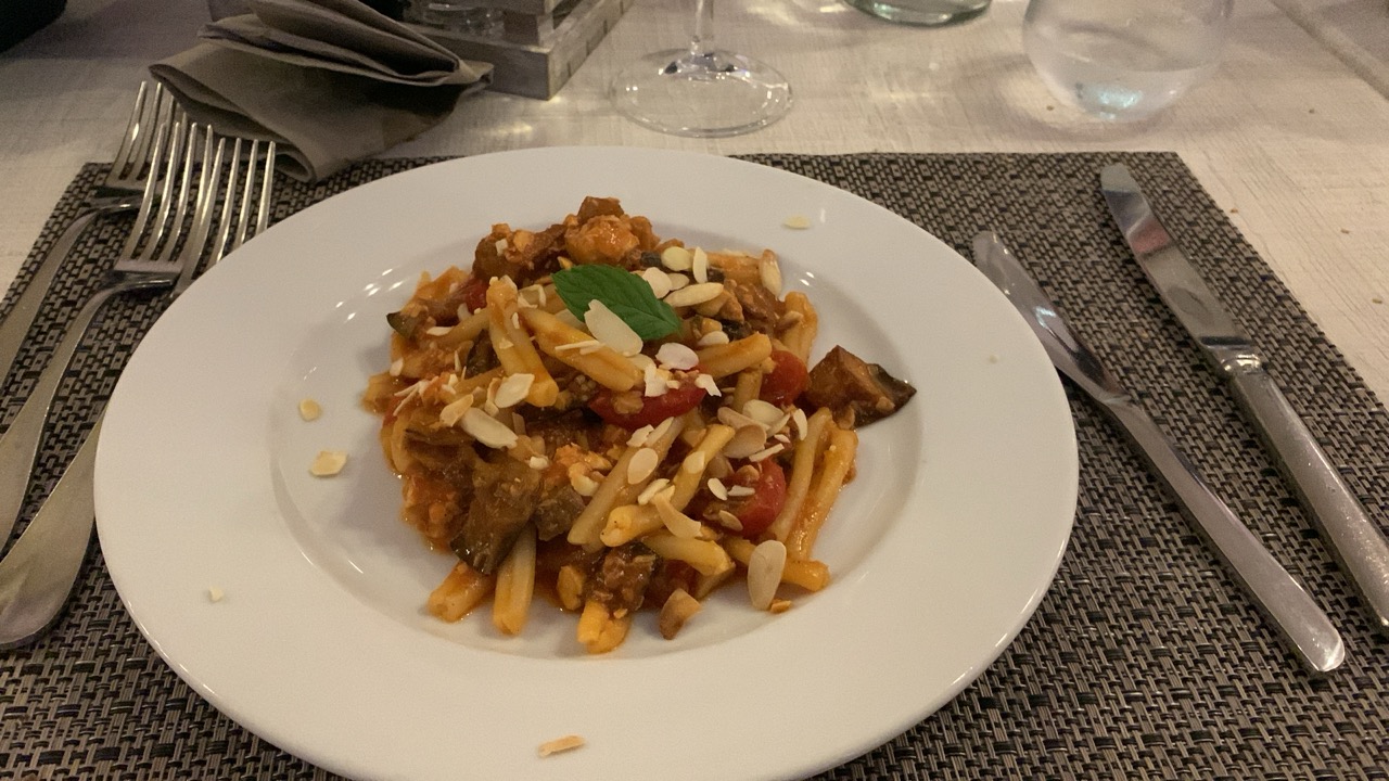 Ein Teller Pasta mit Tomaten und Käse auf dem Tisch