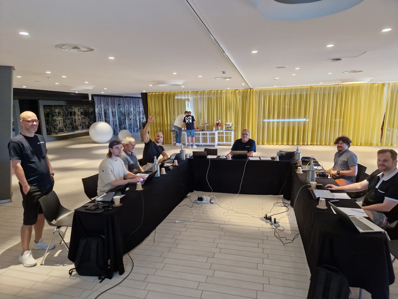 Das Team arbeitet an Tischen in U-Form im Tagungsraum